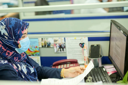 Sintok, Kedah, Malaysia - 11 February, 2020 : a woman had to wear a protective mask while working due to the corona virus that hit the Asian regionのeditorial素材