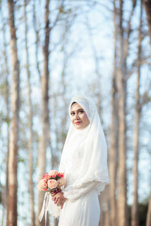 creative outdoor photo shoot of a malay loving couple bride and groom on their wedding wearing a traditional malay dress and camouflage dressの写真素材