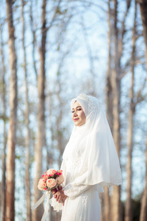 creative outdoor photo shoot of a malay loving couple bride and groom on their wedding wearing a traditional malay dress and camouflage dressの写真素材