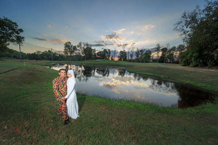 creative outdoor photo shoot of a malay loving couple bride and groom on their wedding wearing a traditional malay dress and camouflage dressの写真素材