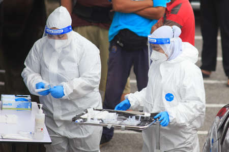 Alor Setar, Kedah, Malaysia - May 20, 2021 : Private clinic make a Swab test in  to local citizen due to Covid-19 positive cases raised up. Selective focus image with noise effectのeditorial素材