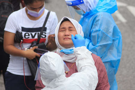 Alor Setar, Kedah, Malaysia - May 20, 2021 : Private clinic make a Swab test in  to local citizen due to Covid-19 positive cases raised up. Selective focus image with noise effectのeditorial素材