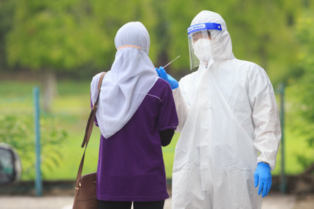 Alor Setar, Kedah, Malaysia - May 20, 2021 : Private clinic make a Swab test in  to local citizen due to Covid-19 positive cases raised up. Selective focus image with noise effectのeditorial素材