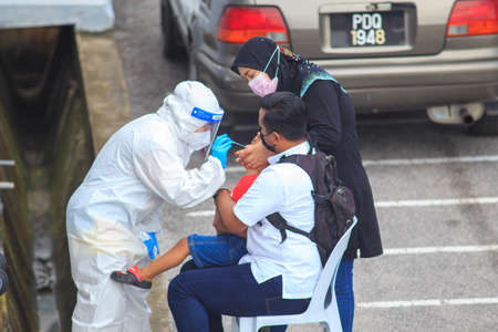 Alor Setar, Kedah, Malaysia - May 20, 2021 : Private clinic make a Swab test in  to local citizen due to Covid-19 positive cases raised up. Selective focus image with noise effectのeditorial素材
