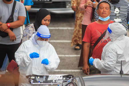 Alor Setar, Kedah, Malaysia - May 20, 2021 : Private clinic make a Swab test in  to local citizen due to Covid-19 positive cases raised up. Selective focus image with noise effectのeditorial素材