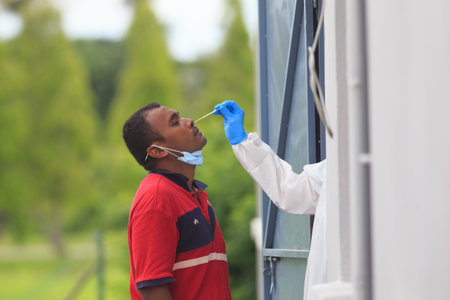 Alor Setar, Kedah, Malaysia - May 20, 2021 : Private clinic make a Swab test in  to local citizen due to Covid-19 positive cases raised up. Selective focus image with noise effectのeditorial素材