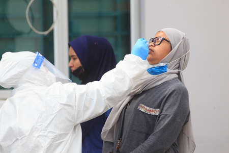 Alor Setar, Kedah, Malaysia - May 20, 2021 : Private clinic make a Swab test in  to local citizen due to Covid-19 positive cases raised up. Selective focus image with noise effectのeditorial素材