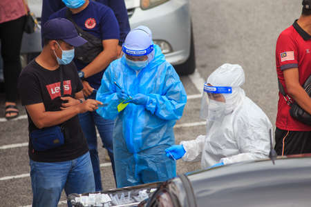 Alor Setar, Kedah, Malaysia - May 20, 2021 : Private clinic make a Swab test in  to local citizen due to Covid-19 positive cases raised up. Selective focus image with noise effectのeditorial素材