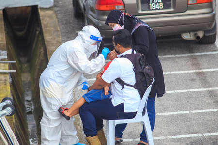 Alor Setar, Kedah, Malaysia - May 20, 2021 : Private clinic make a Swab test in  to local citizen due to Covid-19 positive cases raised up. Selective focus image with noise effectのeditorial素材