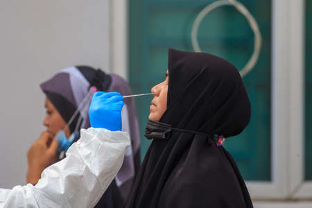 Alor Setar, Kedah, Malaysia - May 20, 2021 : Private clinic make a Swab test in  to local citizen due to Covid-19 positive cases raised up. Selective focus image with noise effectのeditorial素材