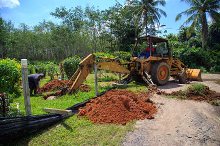 Kedah, Malaysia -May 20, 2021: A man making a grave for funeral at Muslim cemetery.のeditorial素材