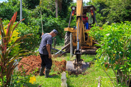 Kedah, Malaysia -May 20, 2021: A man making a grave for funeral at Muslim cemetery.のeditorial素材