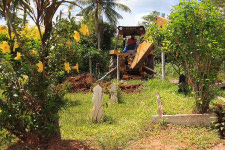 Kedah, Malaysia -May 20, 2021: A man making a grave for funeral at Muslim cemetery.のeditorial素材