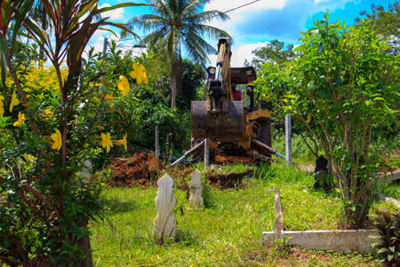 Kedah, Malaysia -May 20, 2021: A man making a grave for funeral at Muslim cemetery.のeditorial素材