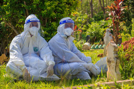 Kuala Lumpur, Malaysia may 2020 - Health workers wearing a PPE suit at graveyard during a funeral for Covid-19 victim in Kuala Lumpur.のeditorial素材