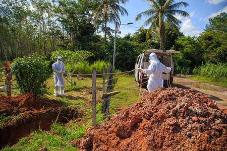 Kuala Lumpur, Malaysia may 2020 - Health workers wearing a PPE suit at graveyard during a funeral for Covid-19 victim in Kuala Lumpur.のeditorial素材
