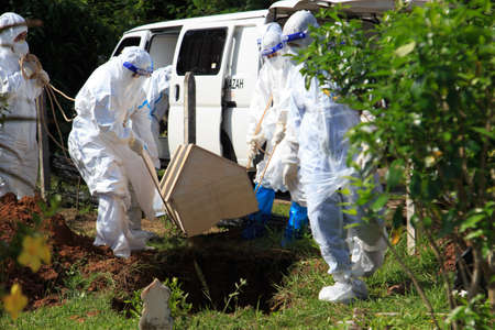 Kuala Lumpur, Malaysia may 2020 - Health workers wearing a PPE suit at graveyard during a funeral for Covid-19 victim in Kuala Lumpur.のeditorial素材