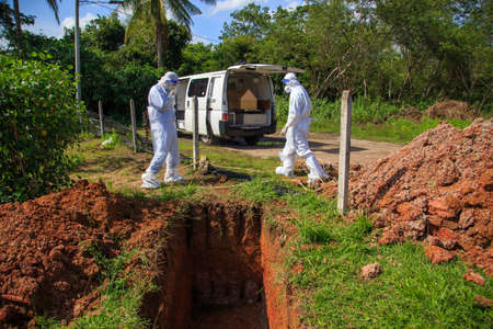 Kuala Lumpur, Malaysia may 2020 - Health workers wearing a PPE suit at graveyard during a funeral for Covid-19 victim in Kuala Lumpur.のeditorial素材