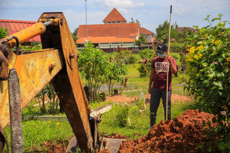 Kuala Lumpur, Malaysia may 2020 - Health workers wearing a PPE suit at graveyard during a funeral for Covid-19 victim in Kuala Lumpur.のeditorial素材