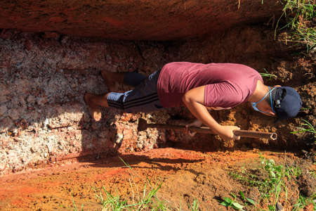 Kedah, Malaysia -May 20, 2021: A man making a grave for funeral at Muslim cemetery.のeditorial素材