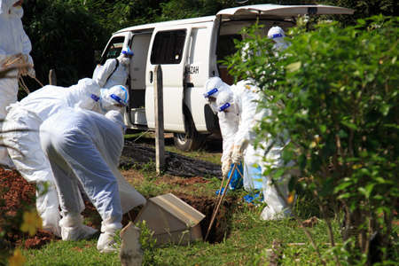 Kuala Lumpur, Malaysia may 2020 - Health workers wearing a PPE suit at graveyard during a funeral for Covid-19 victim in Kuala Lumpur.のeditorial素材