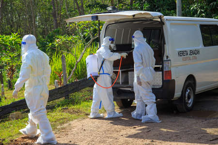 Kuala Lumpur, Malaysia may 2020 - Health workers wearing a PPE suit at graveyard during a funeral for Covid-19 victim in Kuala Lumpur.のeditorial素材