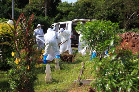 Kuala Lumpur, Malaysia may 2020 - Health workers wearing a PPE suit at graveyard during a funeral for Covid-19 victim in Kuala Lumpur.のeditorial素材