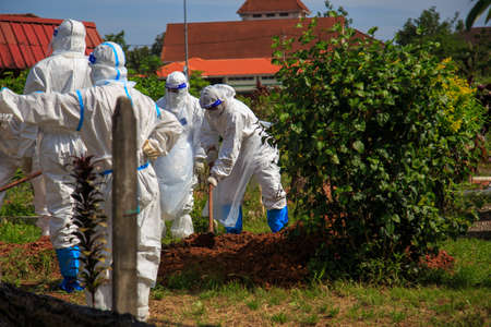 Kuala Lumpur, Malaysia may 2020 - Health workers wearing a PPE suit at graveyard during a funeral for Covid-19 victim in Kuala Lumpur.のeditorial素材