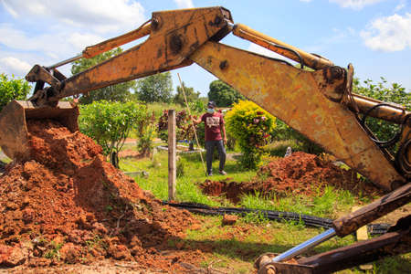 Kedah, Malaysia -May 20, 2021: A man making a grave for funeral at Muslim cemetery.のeditorial素材