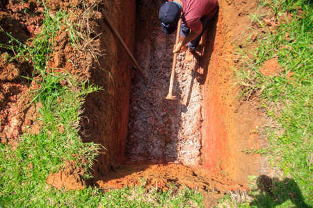 Kedah, Malaysia -May 20, 2021: A man making a grave for funeral at Muslim cemetery.のeditorial素材