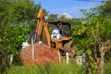Kuala Lumpur, Malaysia may 2020 - Health workers wearing a PPE suit at graveyard during a funeral for Covid-19 victim in Kuala Lumpur.のeditorial素材