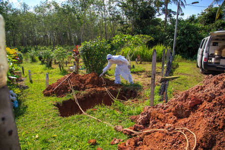 Kuala Lumpur, Malaysia may 2020 - Health workers wearing a PPE suit at graveyard during a funeral for Covid-19 victim in Kuala Lumpur.のeditorial素材