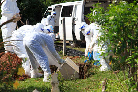 Kuala Lumpur, Malaysia may 2020 - Health workers wearing a PPE suit at graveyard during a funeral for Covid-19 victim in Kuala Lumpur.のeditorial素材