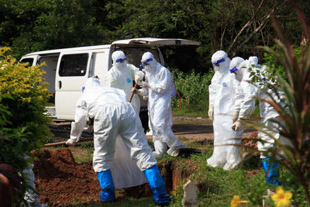 Kuala Lumpur, Malaysia may 2020 - Health workers wearing a PPE suit at graveyard during a funeral for Covid-19 victim in Kuala Lumpur.のeditorial素材