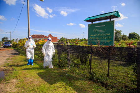 Kuala Lumpur, Malaysia may 2020 - Health workers wearing a PPE suit at graveyard during a funeral for Covid-19 victim in Kuala Lumpur.のeditorial素材
