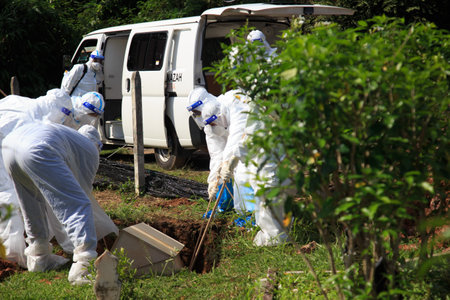 Kuala Lumpur, Malaysia may 2020 - Health workers wearing a PPE suit at graveyard during a funeral for Covid-19 victim in Kuala Lumpur.のeditorial素材
