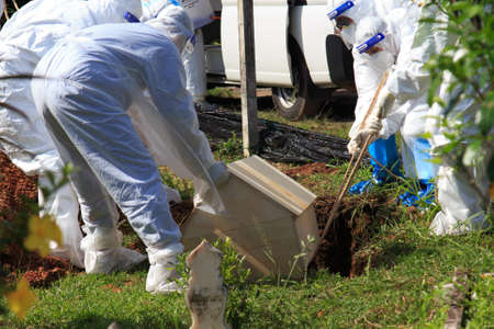 Kuala Lumpur, Malaysia may 2020 - Health workers wearing a PPE suit at graveyard during a funeral for Covid-19 victim in Kuala Lumpur.のeditorial素材