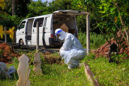 Kuala Lumpur, Malaysia may 2020 - Health workers wearing a PPE suit at graveyard during a funeral for Covid-19 victim in Kuala Lumpur.のeditorial素材