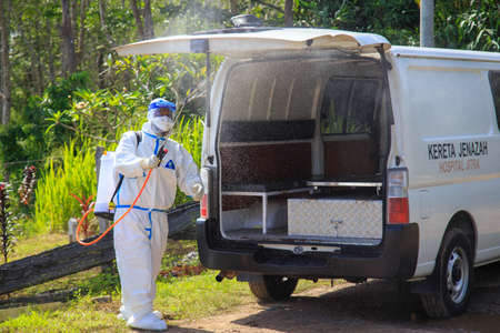 Kuala Lumpur, Malaysia may 2020 - Health workers wearing a PPE suit at graveyard during a funeral for Covid-19 victim in Kuala Lumpur.のeditorial素材