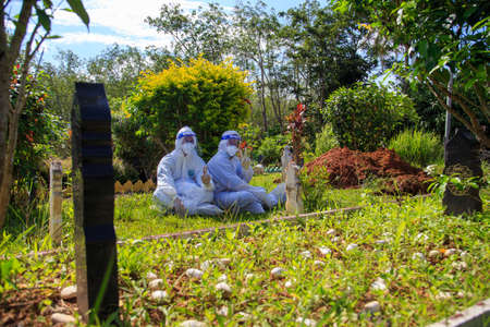 Kuala Lumpur, Malaysia may 2020 - Health workers wearing a PPE suit at graveyard during a funeral for Covid-19 victim in Kuala Lumpur.のeditorial素材