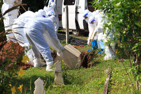 Kuala Lumpur, Malaysia may 2020 - Health workers wearing a PPE suit at graveyard during a funeral for Covid-19 victim in Kuala Lumpur.のeditorial素材