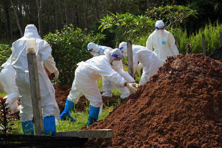 Kuala Lumpur, Malaysia may 2020 - Health workers wearing a PPE suit at graveyard during a funeral for Covid-19 victim in Kuala Lumpur.のeditorial素材