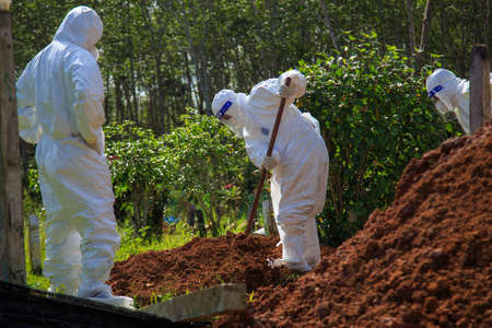 Kuala Lumpur, Malaysia may 2020 - Health workers wearing a PPE suit at graveyard during a funeral for Covid-19 victim in Kuala Lumpur.のeditorial素材