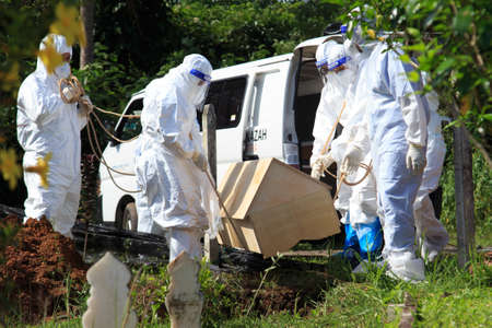 Kuala Lumpur, Malaysia may 2020 - Health workers wearing a PPE suit at graveyard during a funeral for Covid-19 victim in Kuala Lumpur.のeditorial素材