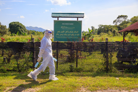 Kuala Lumpur, Malaysia may 2020 - Health workers wearing a PPE suit at graveyard during a funeral for Covid-19 victim in Kuala Lumpur.のeditorial素材
