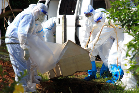 Kuala Lumpur, Malaysia may 2020 - Health workers wearing a PPE suit at graveyard during a funeral for Covid-19 victim in Kuala Lumpur.のeditorial素材