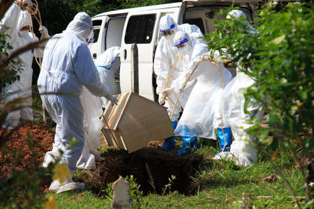 Kuala Lumpur, Malaysia may 2020 - Health workers wearing a PPE suit at graveyard during a funeral for Covid-19 victim in Kuala Lumpur.のeditorial素材