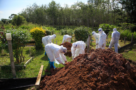 Kuala Lumpur, Malaysia may 2020 - Health workers wearing a PPE suit at graveyard during a funeral for Covid-19 victim in Kuala Lumpur.のeditorial素材