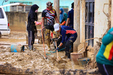 Pahang, Malaysia: January 1, 2022: A group of volunteers help clean the houses of residents affected...