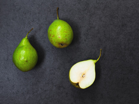Three  pears on gray stone background, top view